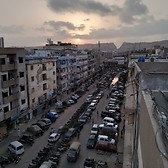 Capitalism keeping people busy that they are missing on the sun setting behind the mountains