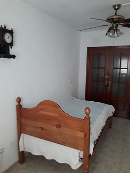 Habitación luminosa con cama rústica individual