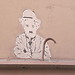 Charlie Chaplin sur un mur, qui picote du pain dur...
