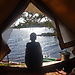 Kayaks on a lake and a Man in a Tent